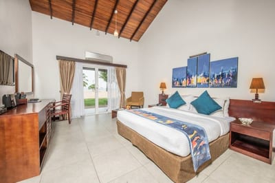 Amethyst Resort - spacious bedroom with wooden ceiling, blue artwork above bed, and garden view doors