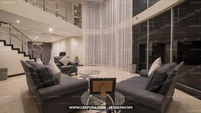 W Residence Kandy, - modern living room with gray sofas, floor-to-ceiling windows and staircase